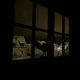 Ein Blick aus dem Fenster aus einem dunklen Schlafzimmer. Man sieht Einfamilienhäuser mit schneebedeckten Dächern bei Nacht.