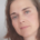 Linda, eine Frau mit schulterlangen braunen Haaren und grünlichen Augen