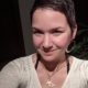 Karina, eine Frau mit kurzen braunen Haaren und große silbernen Ohrringen